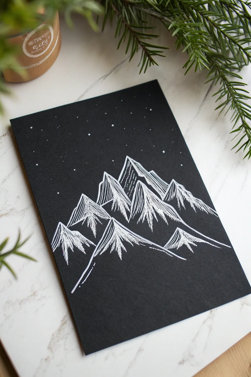 Snowy mountain ridges glowing in crisp white on black paper, minimal and striking with bold contrast