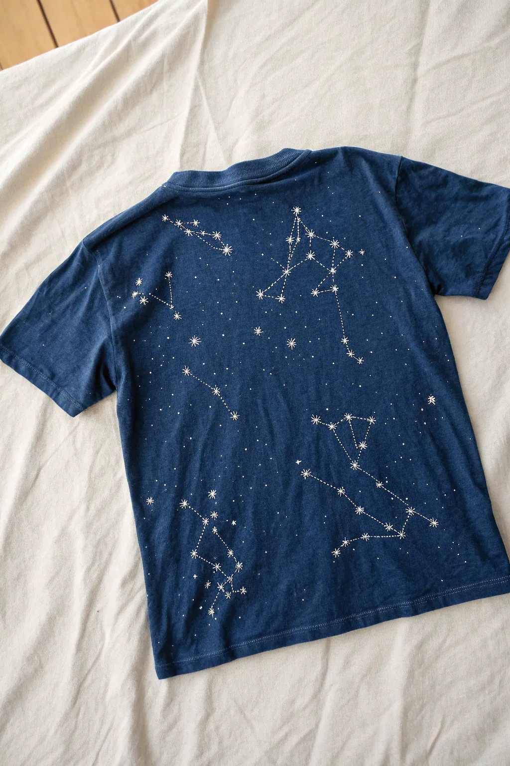 Bleach painted constellation back panel for a cosmic minimalist DIY with bold contrast on dark cotton.