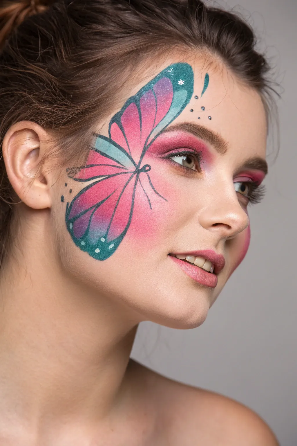 Thin-line butterfly outline over a vibrant color wash for an effortless, graphic face paint look