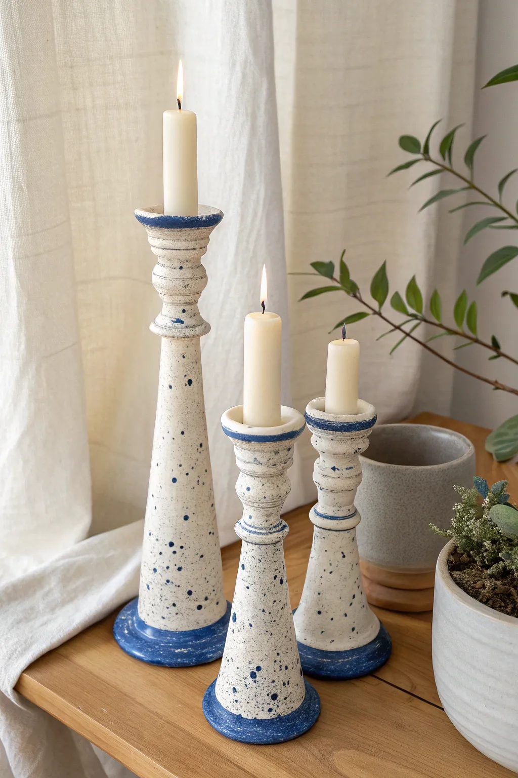 Matched ceramic taper holders with playful glaze drips, Nordic minimalism with a boho touch.
