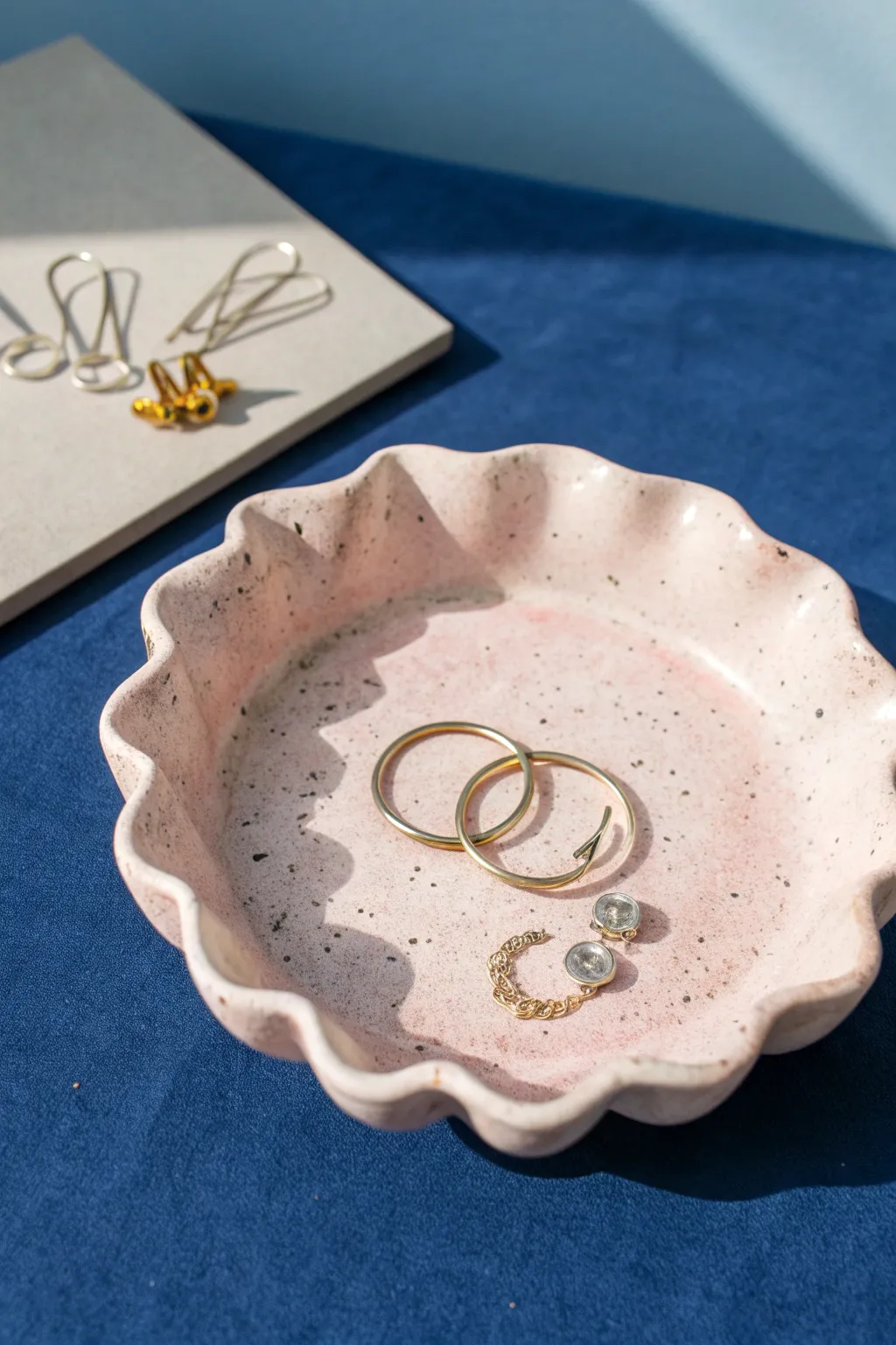 Pastel wavy-rim trinket dish for earrings and paper clips, minimalist boho with bold contrast.