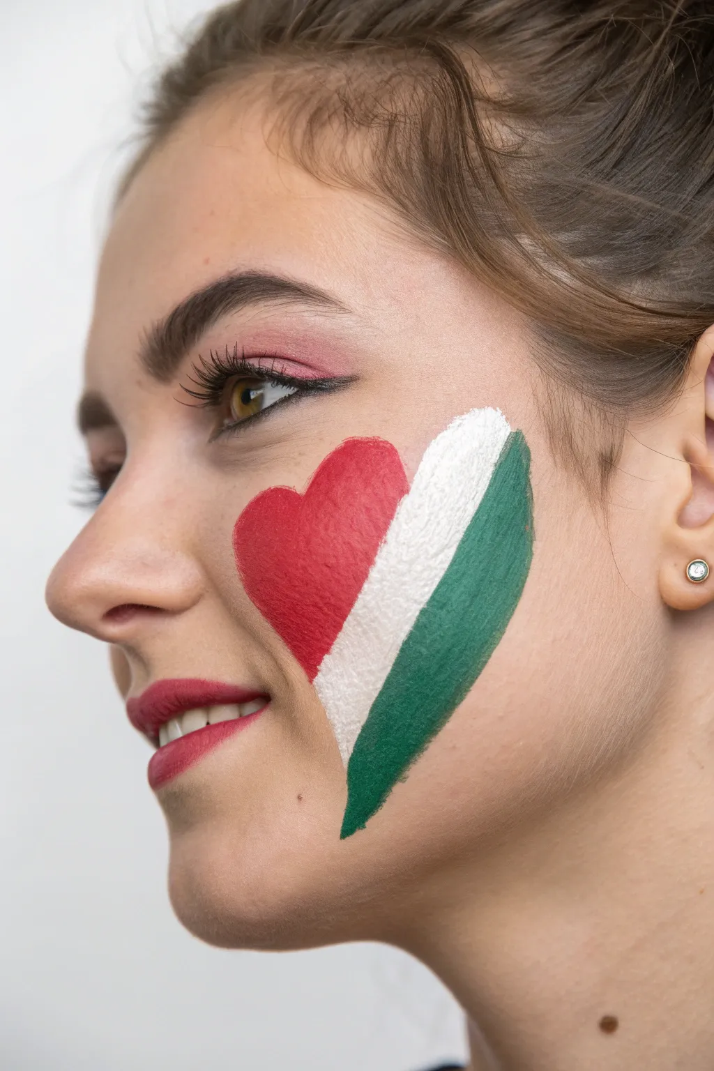 Five-band heart cheek art in gold, dark, red, white, and green with crisp, bold contrast