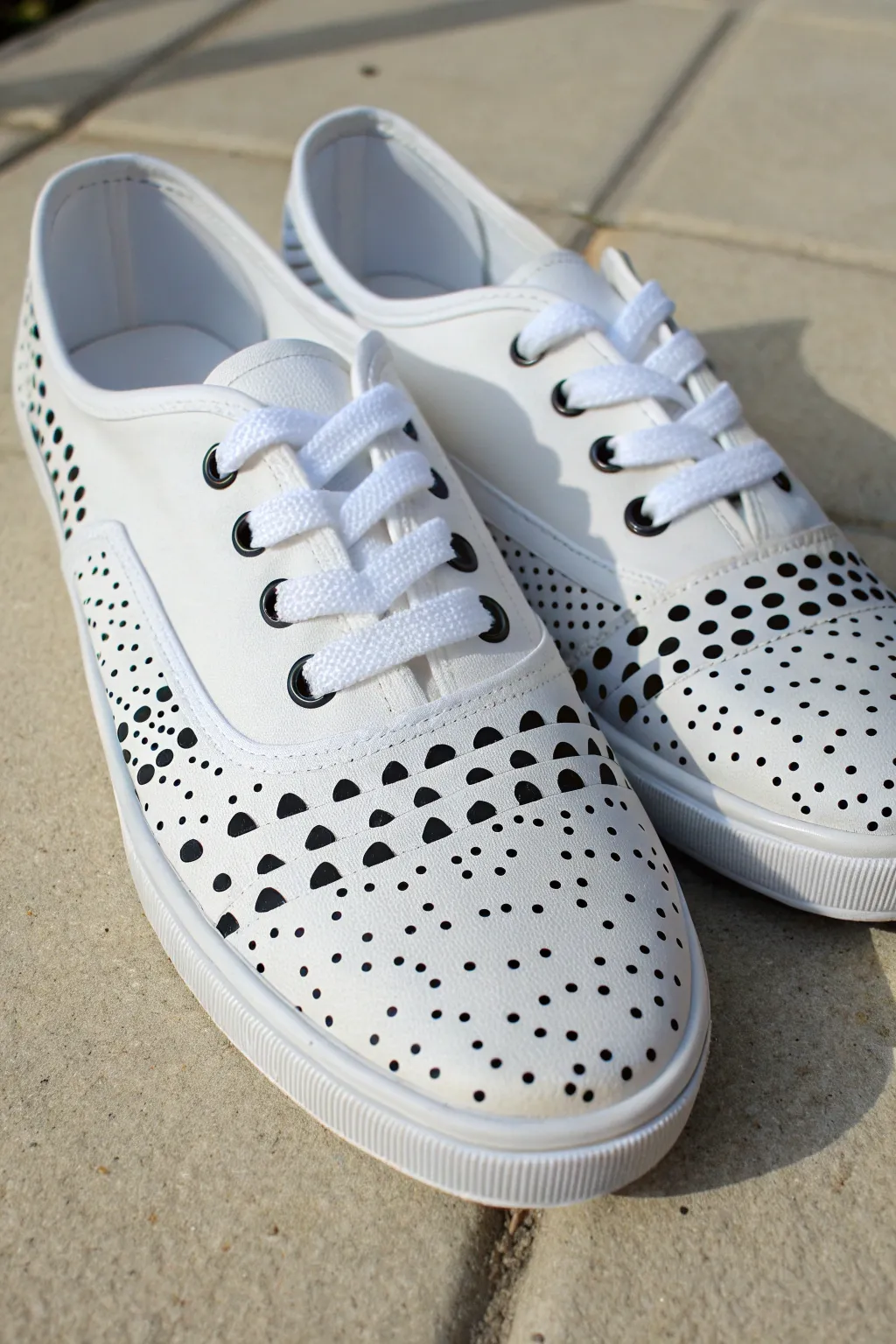 Minimal monochrome repeat dots on crisp white sneakers for a chic, Scandinavian-cool look