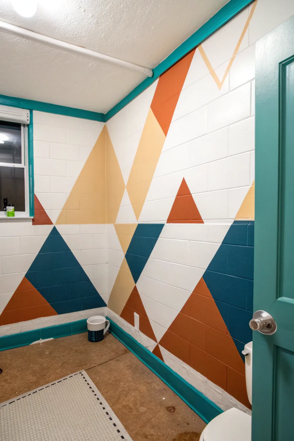 Bold tape-defined color blocks turn a simple bathroom corner into striking geometric style.