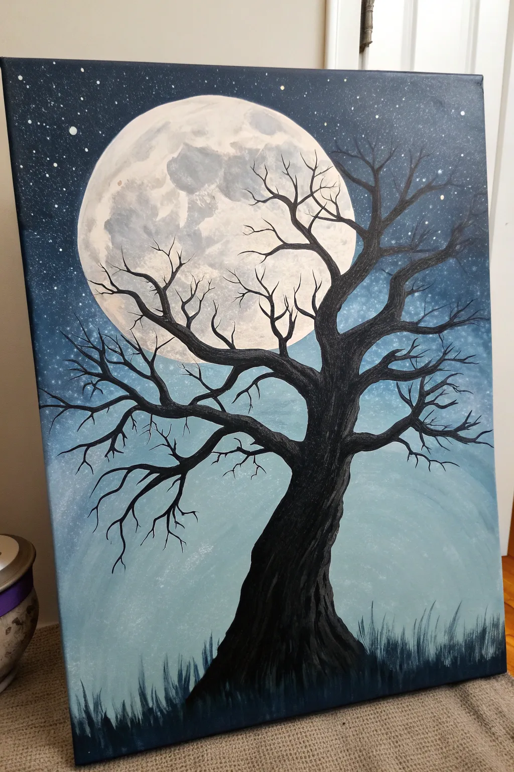 Paint a bold bare tree silhouette on a misty moonlit sky for an easy spooky Halloween canvas.