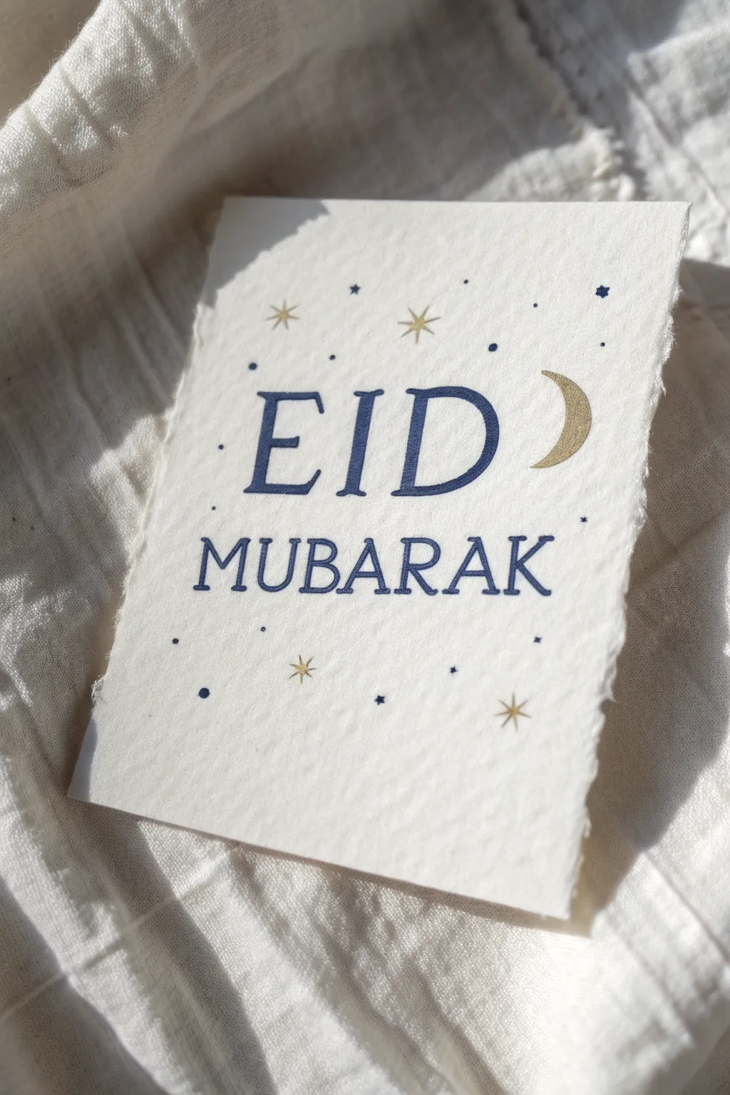 Minimal Eid card idea: hand-lettered greeting with crescent and stars in bold indigo and gold
