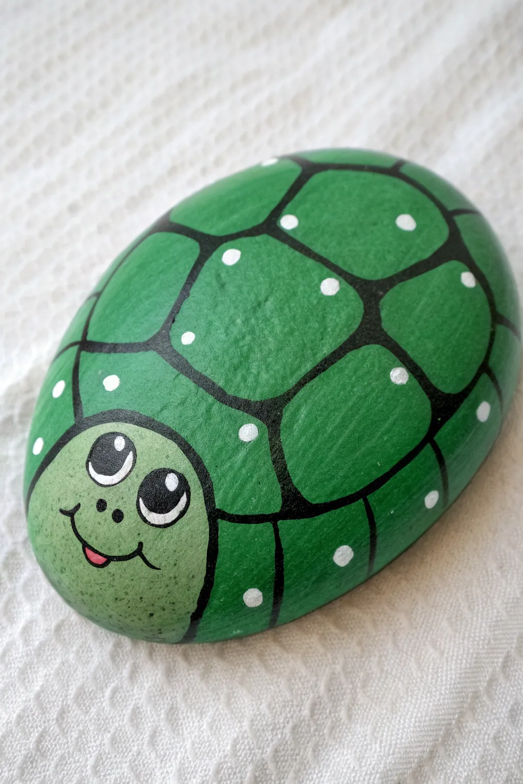 Turtle shell rock painting made simple for kids, bold greens on a calm minimalist backdrop.
