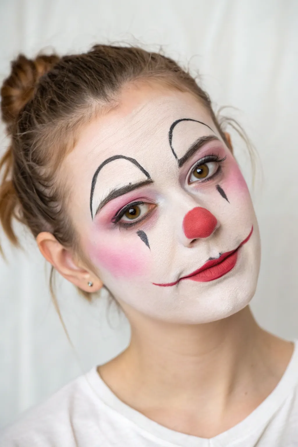 Creepy-pretty clown cheeks with sharp white-highlight lines and bold blush for Halloween