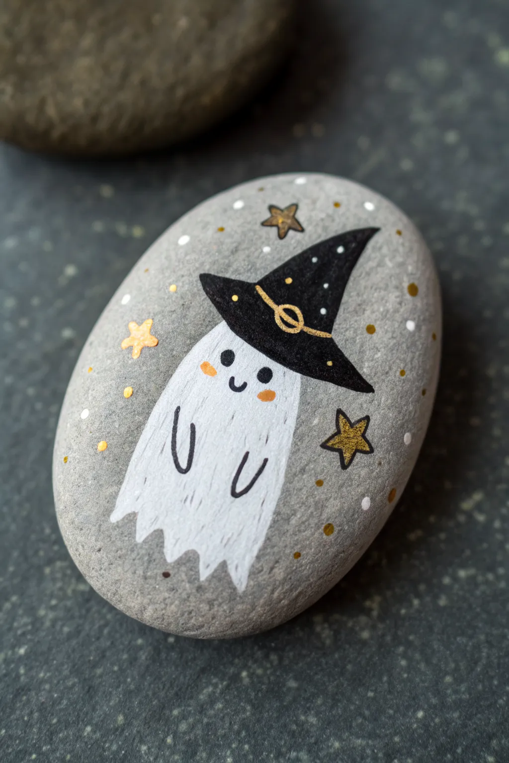 Minimal ghost rock with a witch hat, bold contrast and tiny star details for chic Halloween craft inspo