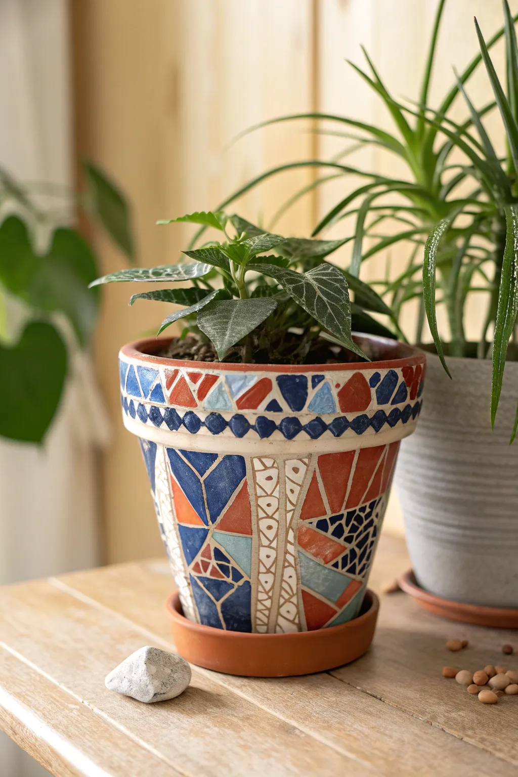 Terracotta pot with bold mosaic wrap and leafy spillover, simple Scandinavian boho craft vibe