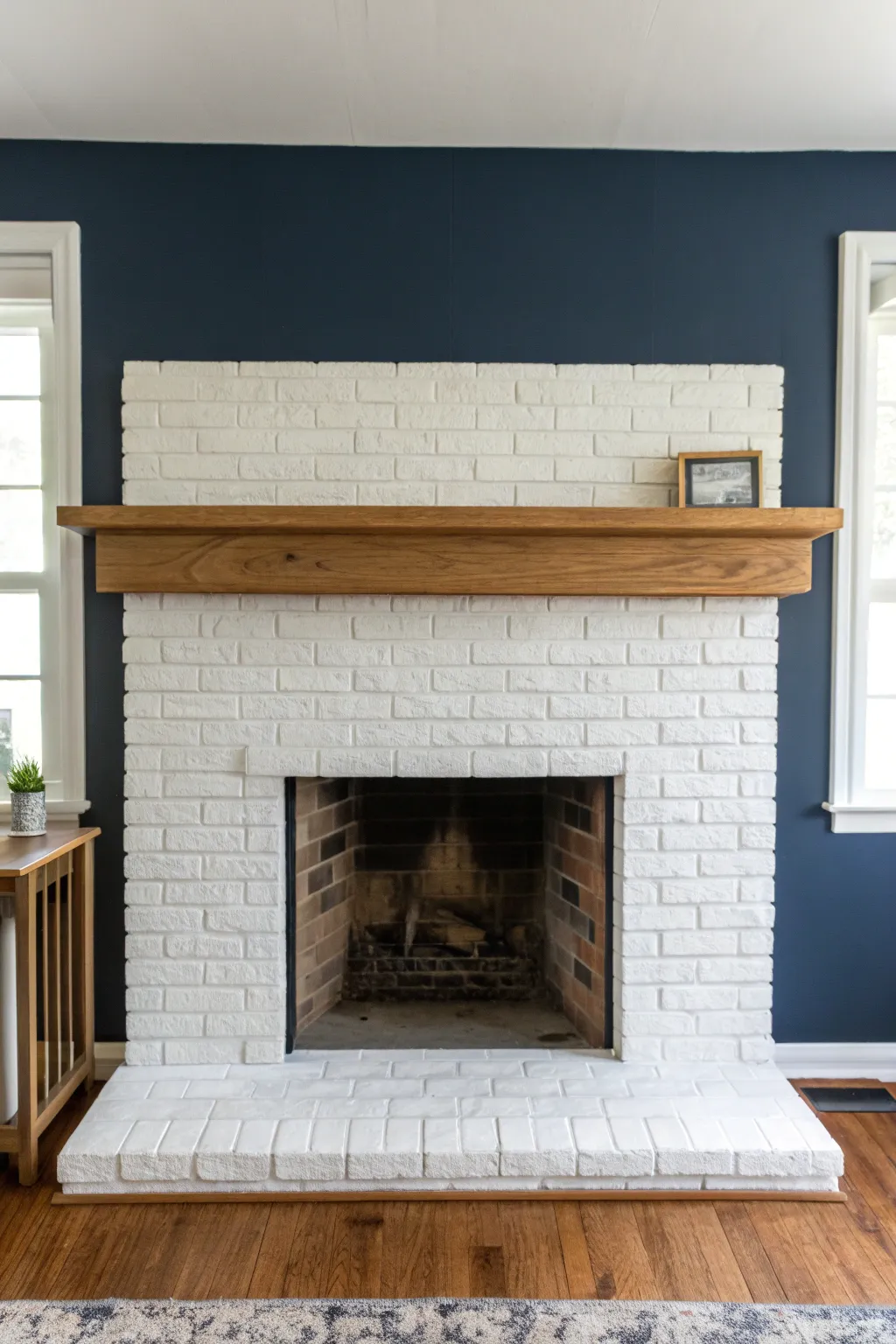 Crisp white painted brick paired with a warm oak mantel for effortless modern contrast.