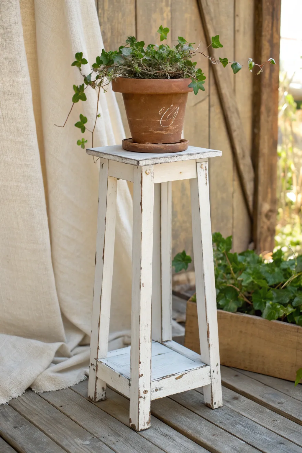 Distressed white plant stand with ivy for a cozy vintage farmhouse corner in minimalist style