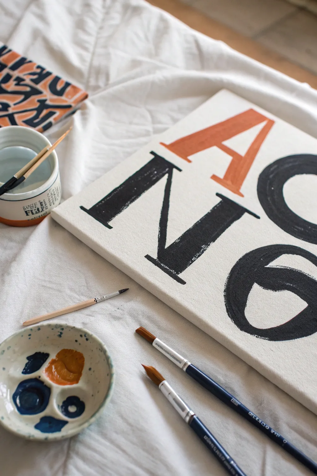 Craft a personalized quote style canvas with bold strokes, minimalist palette, and studio flat lay vibes