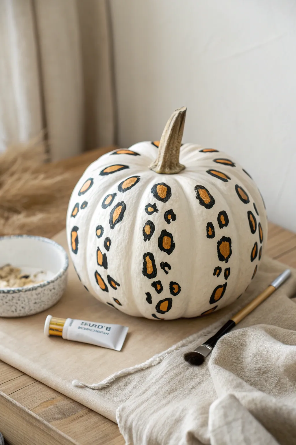 Neutral leopard-print pumpkin with airy white space, chic preppy DIY fall decor idea.