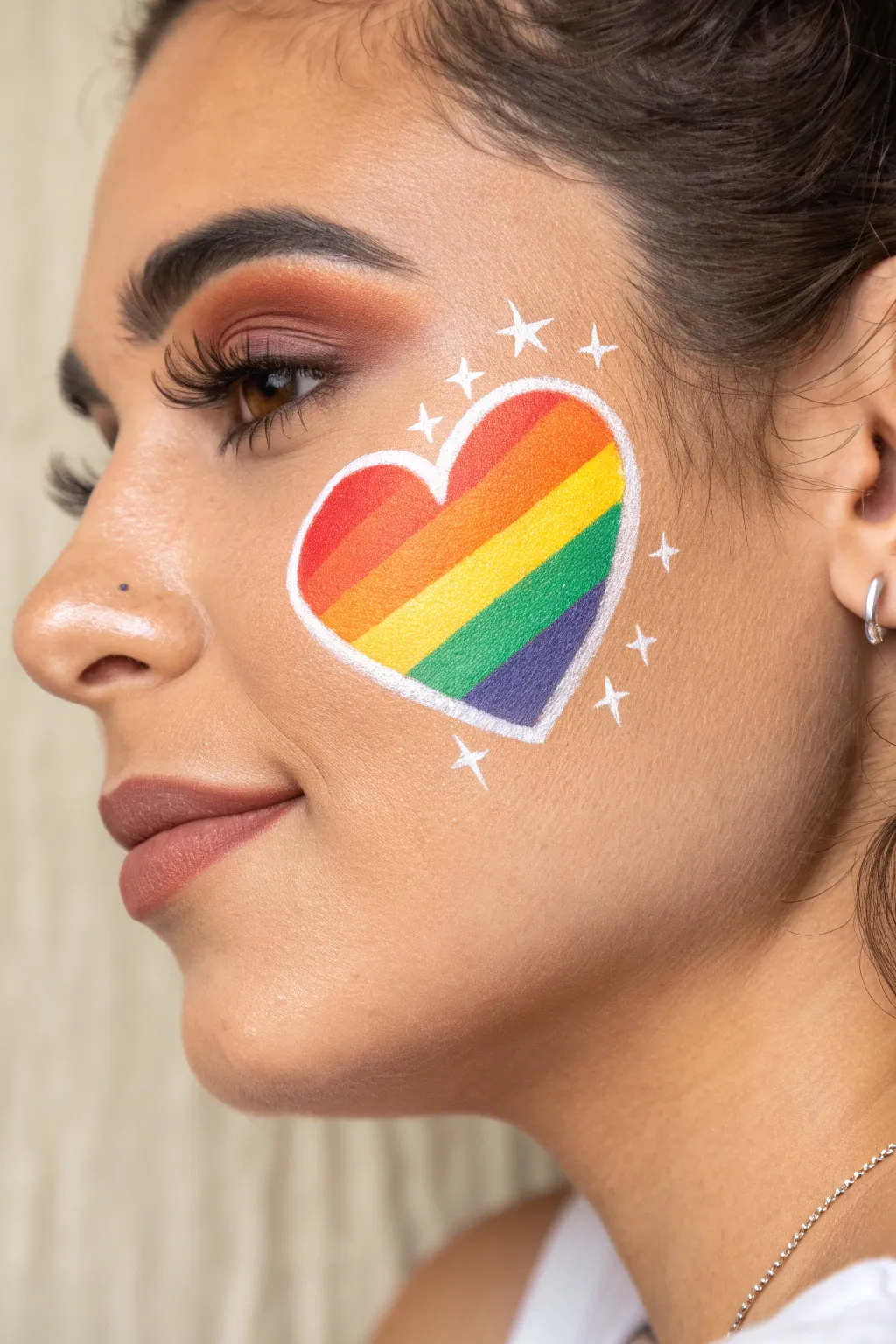 Rainbow heart cheek accent with crisp white outline and tiny starbursts, bold yet minimal.