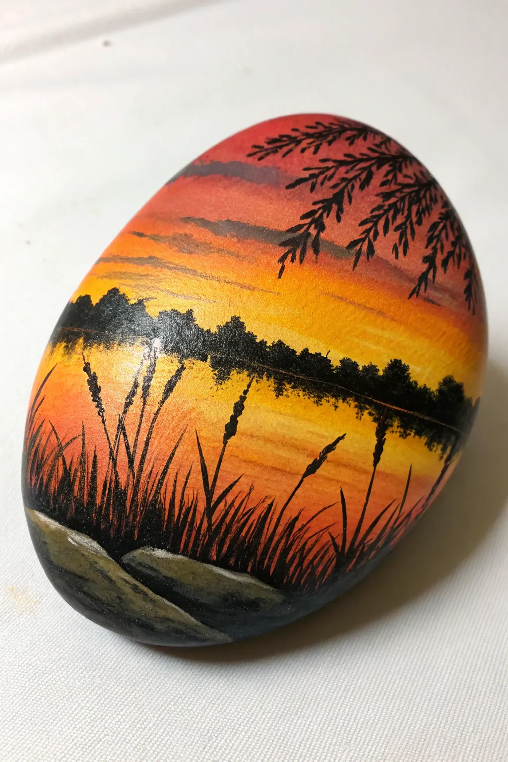 Sunset lake rock painting with bold cattail silhouettes, minimalist calm and glowing reflection