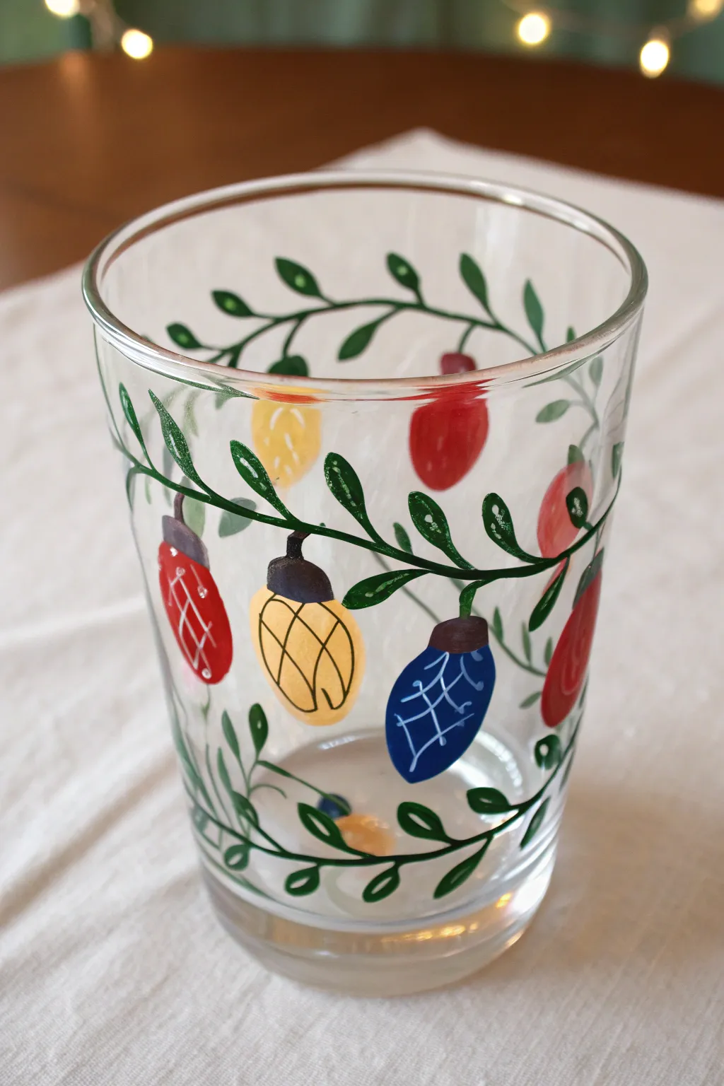 Minimal Christmas bulb garland painted on clear glass with warm glow and bold festive contrast