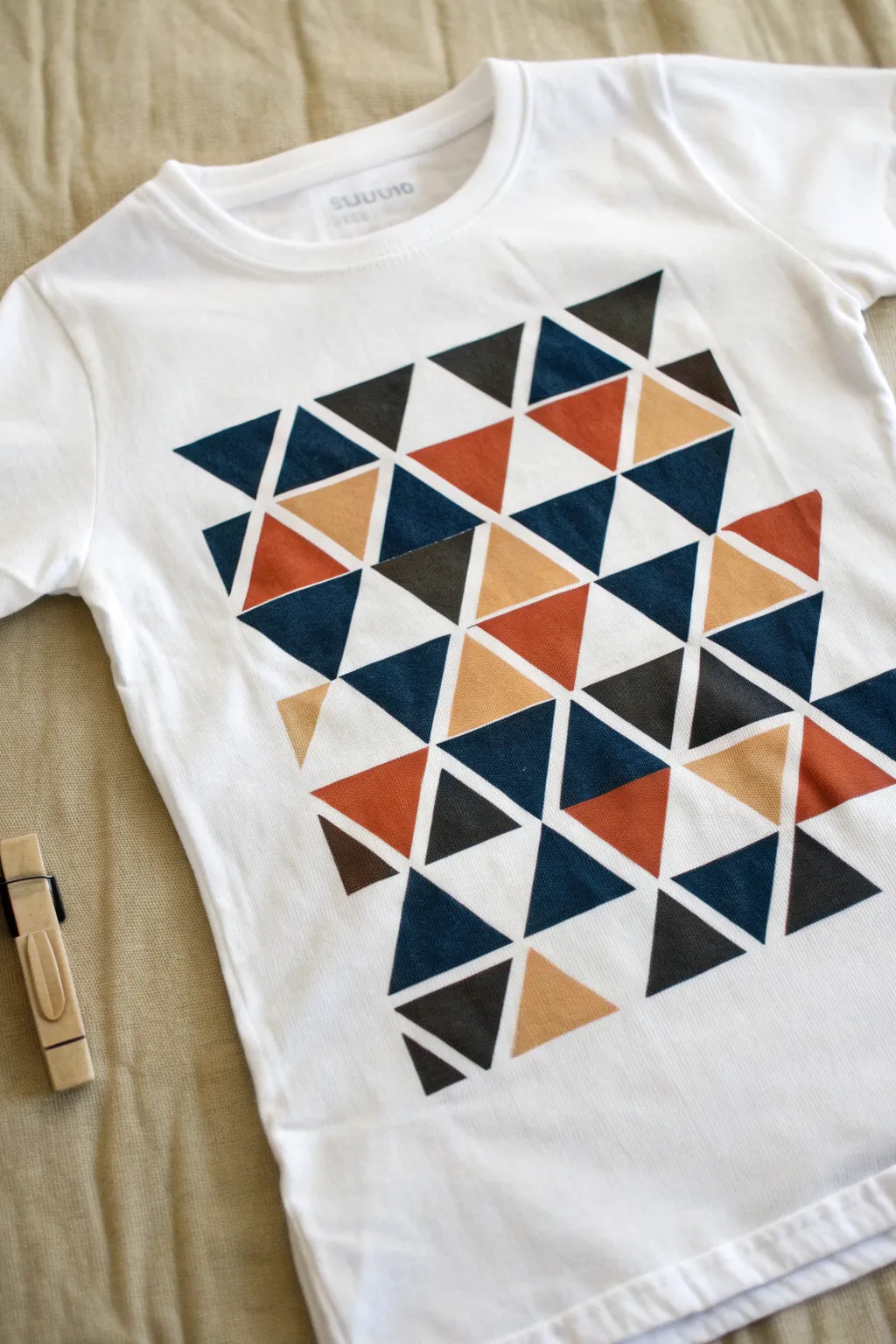 Crisp tape-resist triangles in bold color blocks for a clean, modern painted t-shirt look