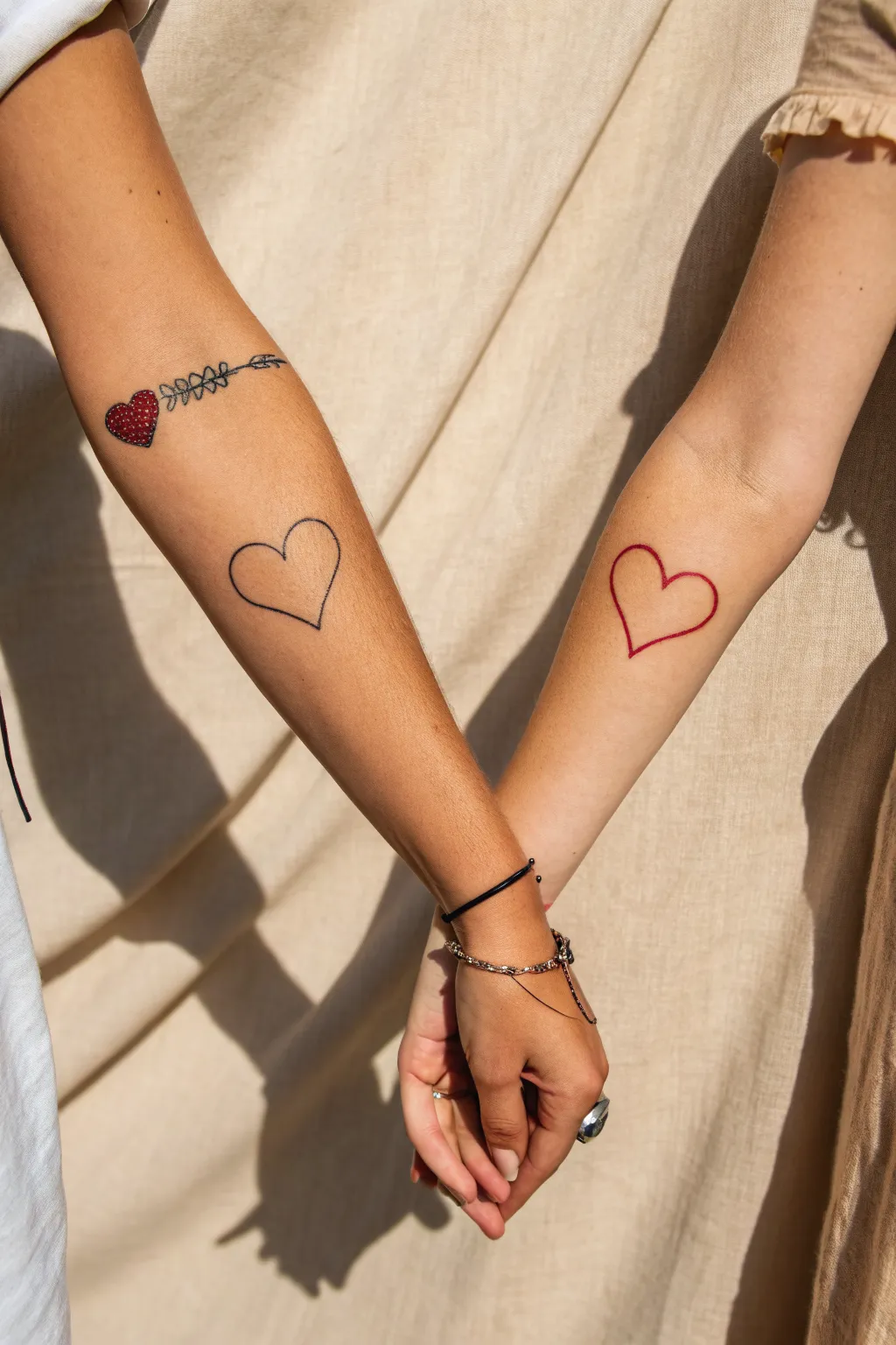 Split heart tattoos that meet perfectly when hands touch, minimal lines with a bold red pop