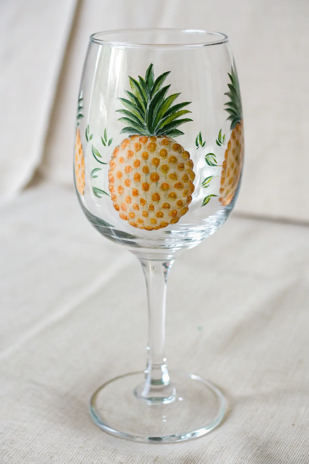 Pineapple dot painting on a wine glass with crisp texture, bold color, and minimalist charm