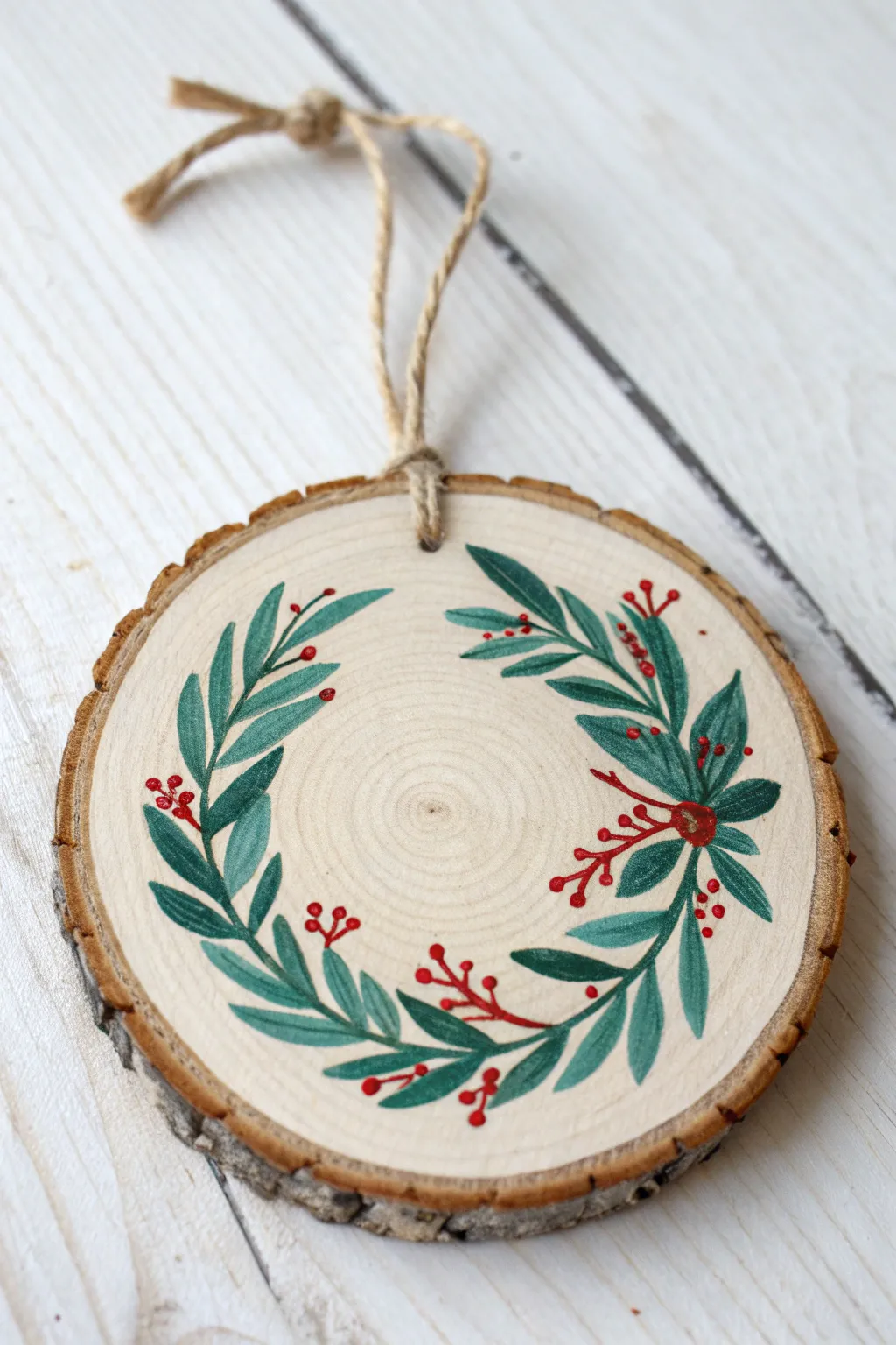Minimal botanical wreath wood ornament with twine hanger, painted in bold earthy tones.