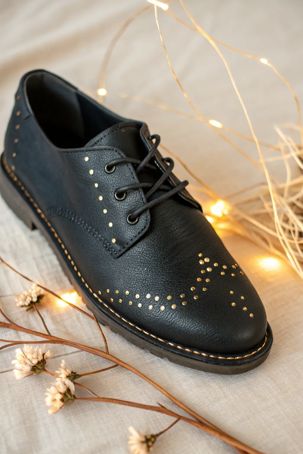 Matte black shoe with tiny metallic details, softly reflecting window light in a minimal scene