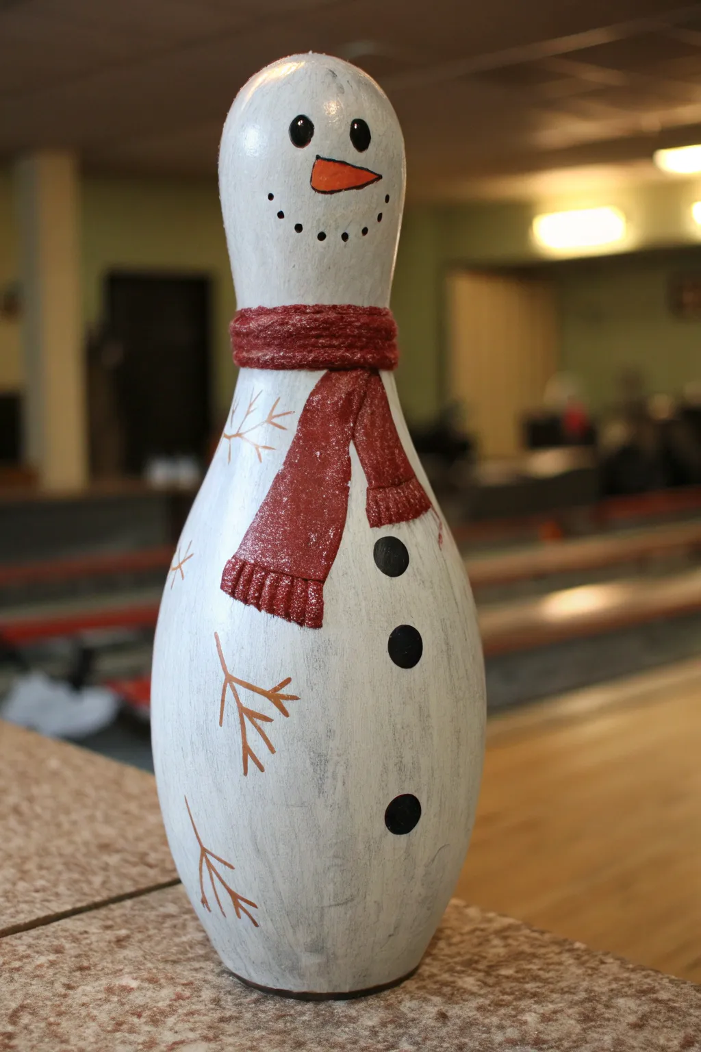 Cozy snowman bowling pin DIY: scarf band, coal smile, carrot nose, and softly shaded whites.