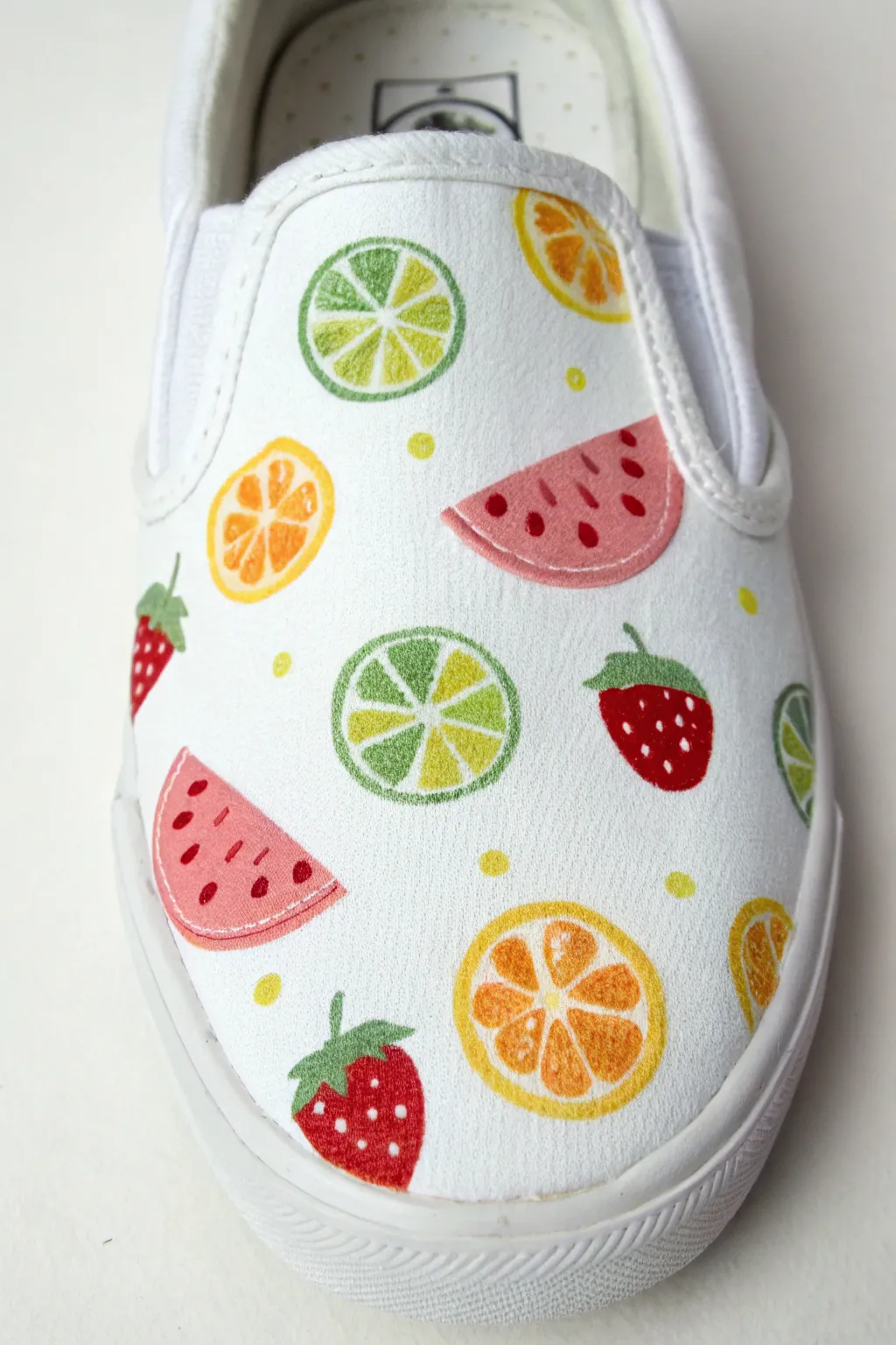 Bright fruit-slice canvas shoe art on crisp white for fresh, summery minimalist vibes
