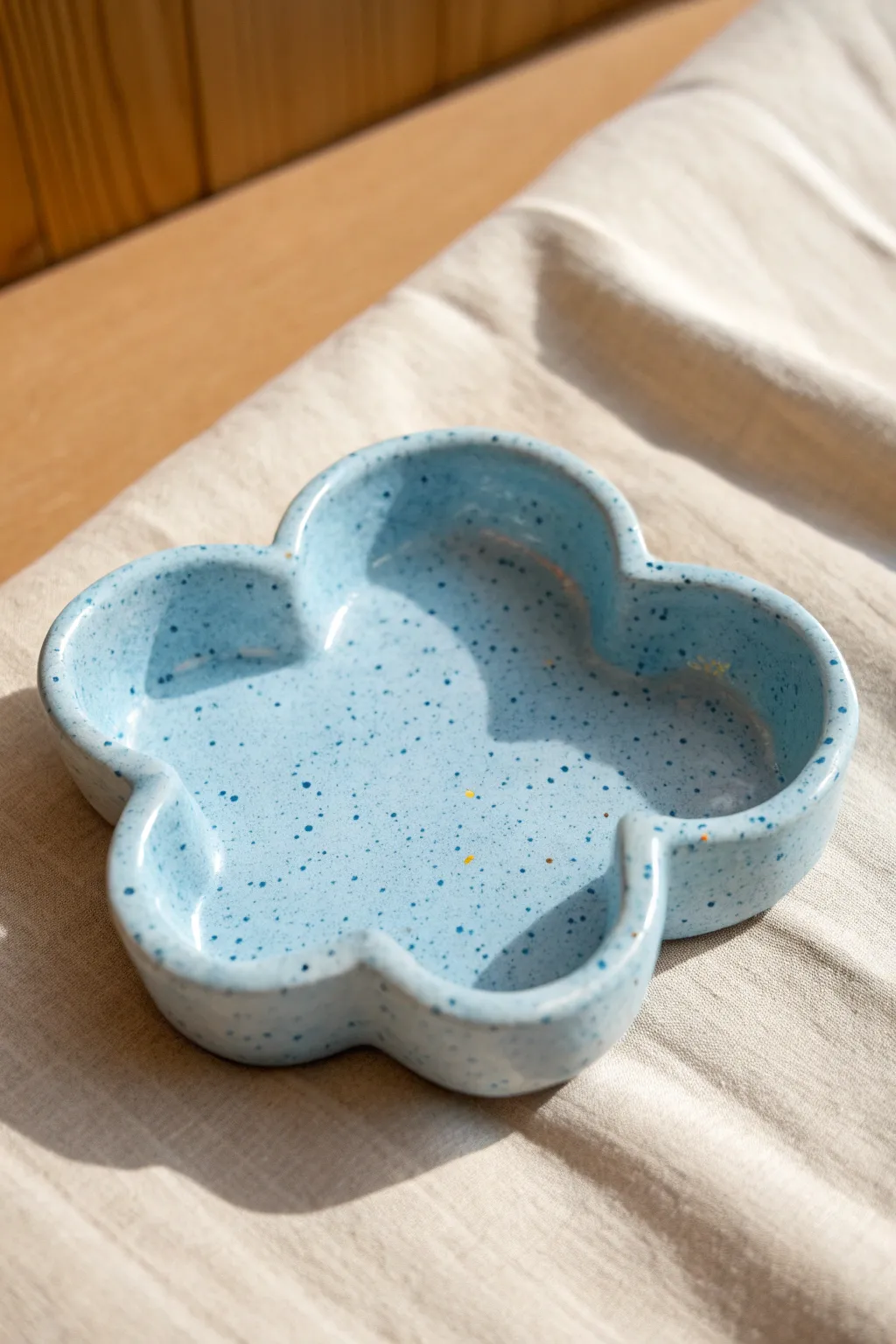 Airy blue cloud ashtray with soft curves and speckles, a dreamy minimalist clay idea