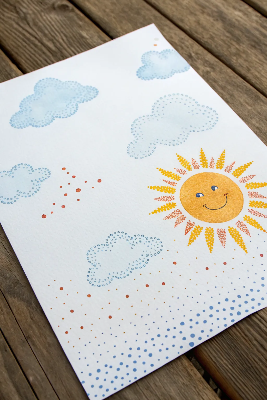 Sunny sky dot painting for kids with a warm dotted sun, soft clouds, and calming blue dot background.