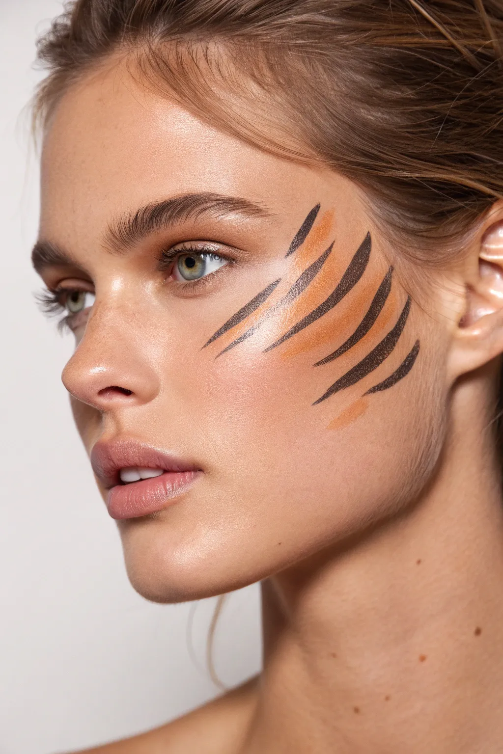 Three bold tiger stripe scratch marks across the cheekbone, high-contrast and easy to recreate.