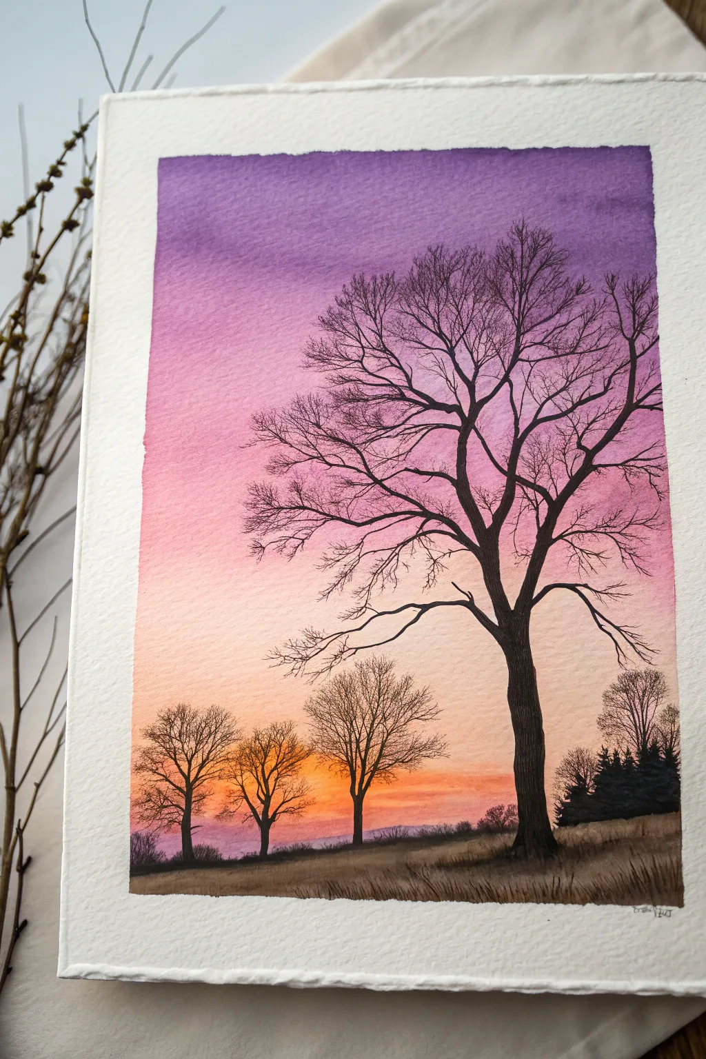 Paint a dreamy fall sunset gradient with stark bare tree silhouettes for instant drama
