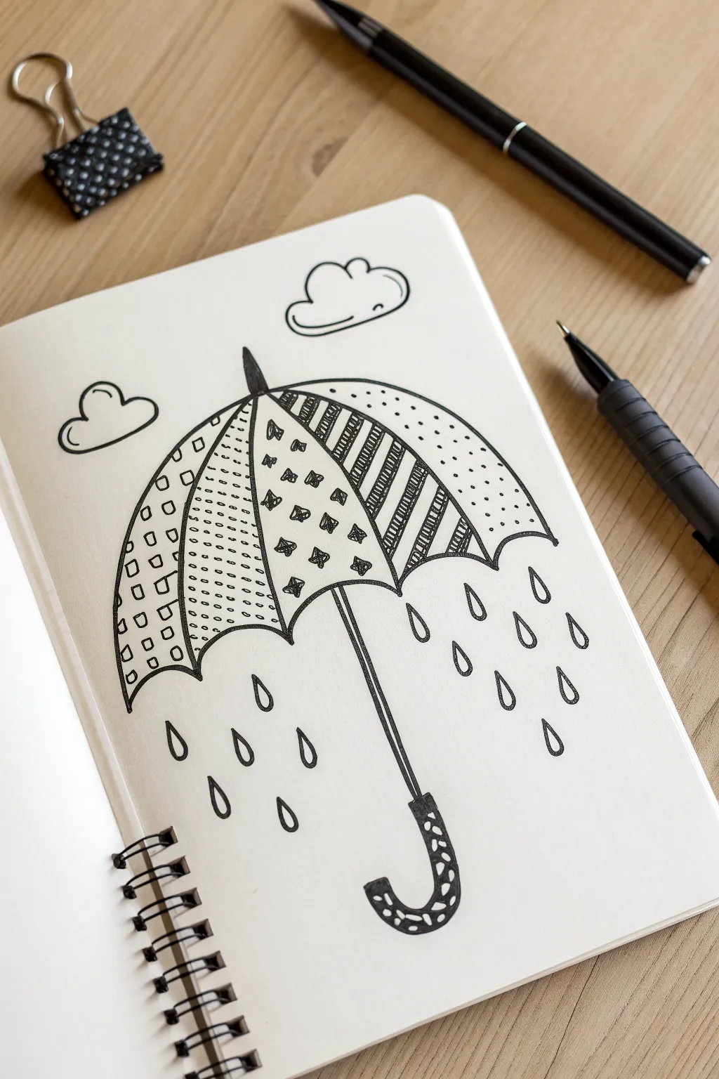 Minimal umbrella doodle with easy patterns and raindrops, a cozy March drawing idea