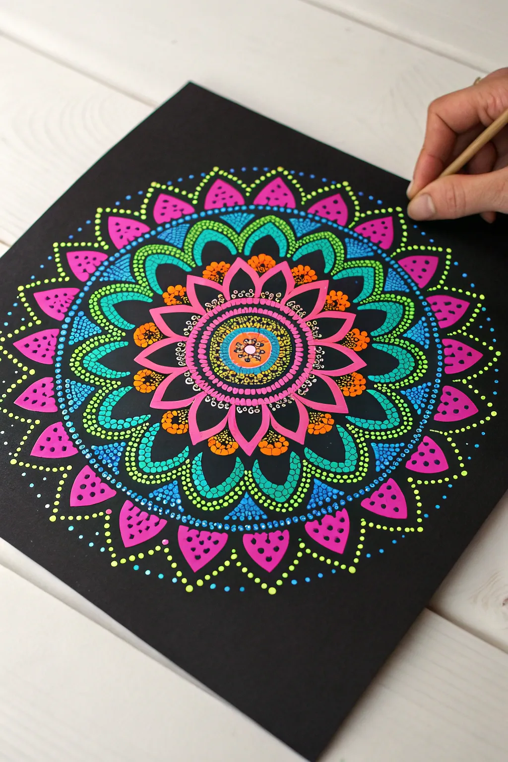 Fluorescent mandala dotwork on black paper, crisp dots and a soft UV glow with bold contrast.