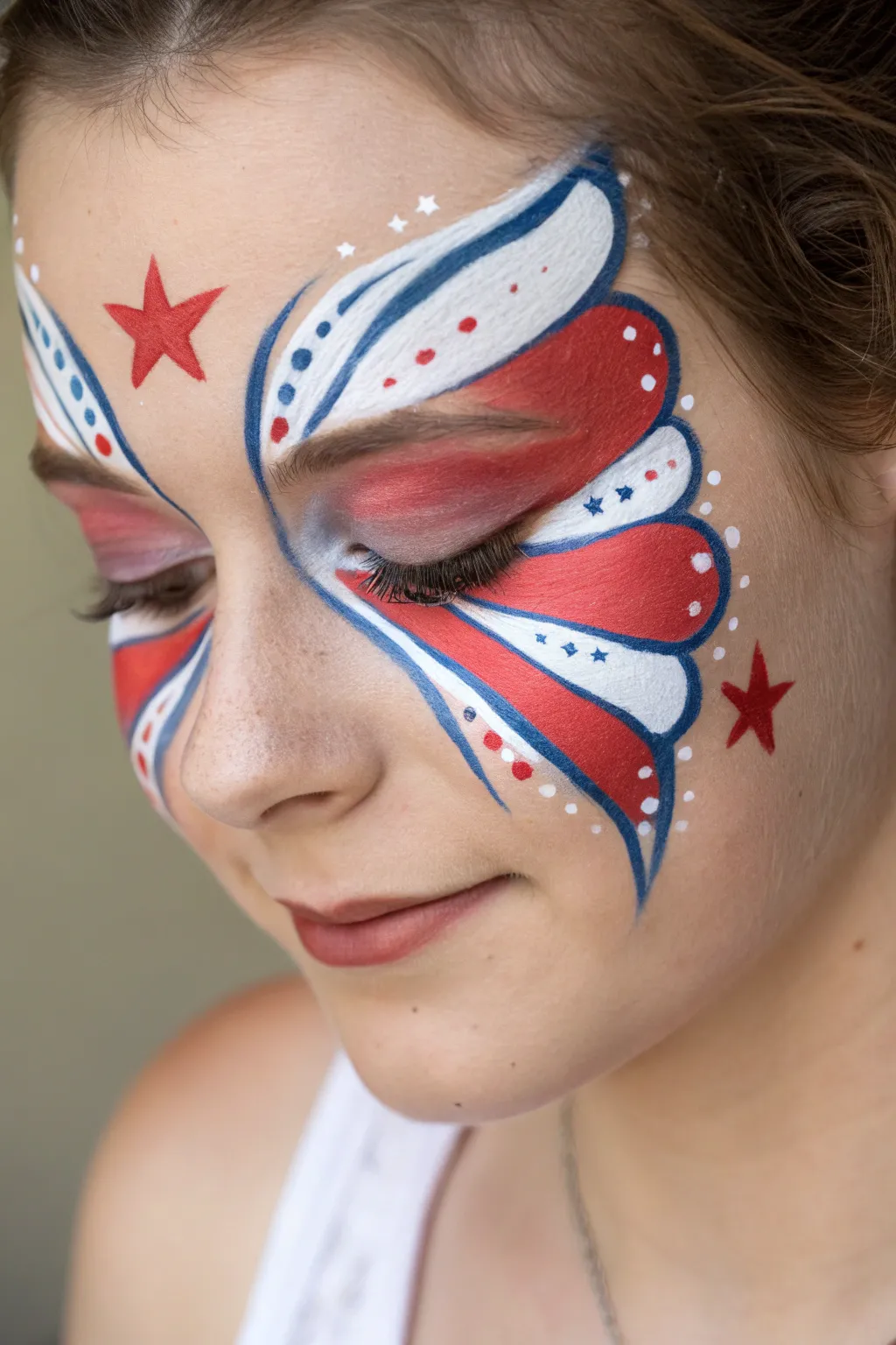 Red, white, and blue butterfly eyes with tiny stars for a chic Fourth of July face paint idea
