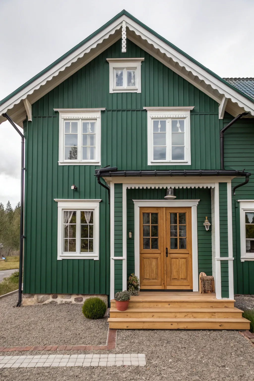 Deep green siding with warm white trim for a serene, woodsy exterior that feels timeless