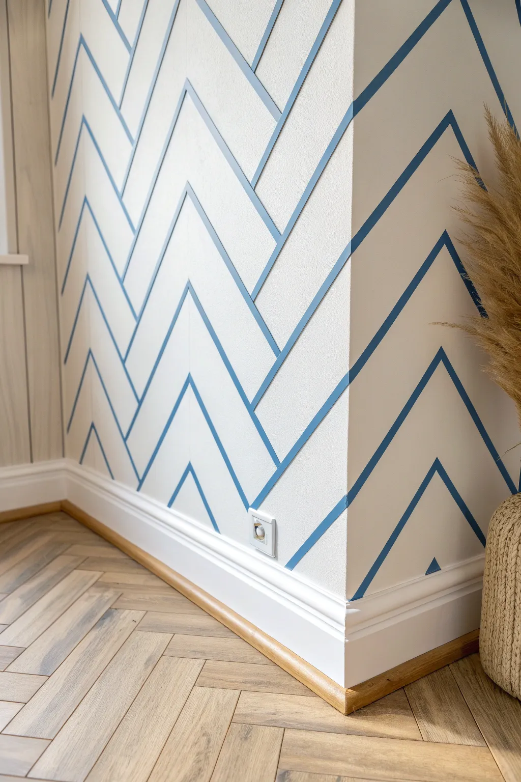 Crisp herringbone tape layout with alternating paint for a tailored, high-contrast wall detail.