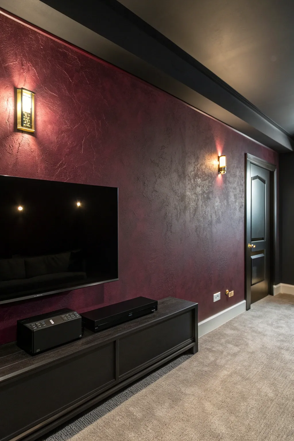 Deep burgundy accent wall with warm sconces brings classic cinema drama to a minimalist media room