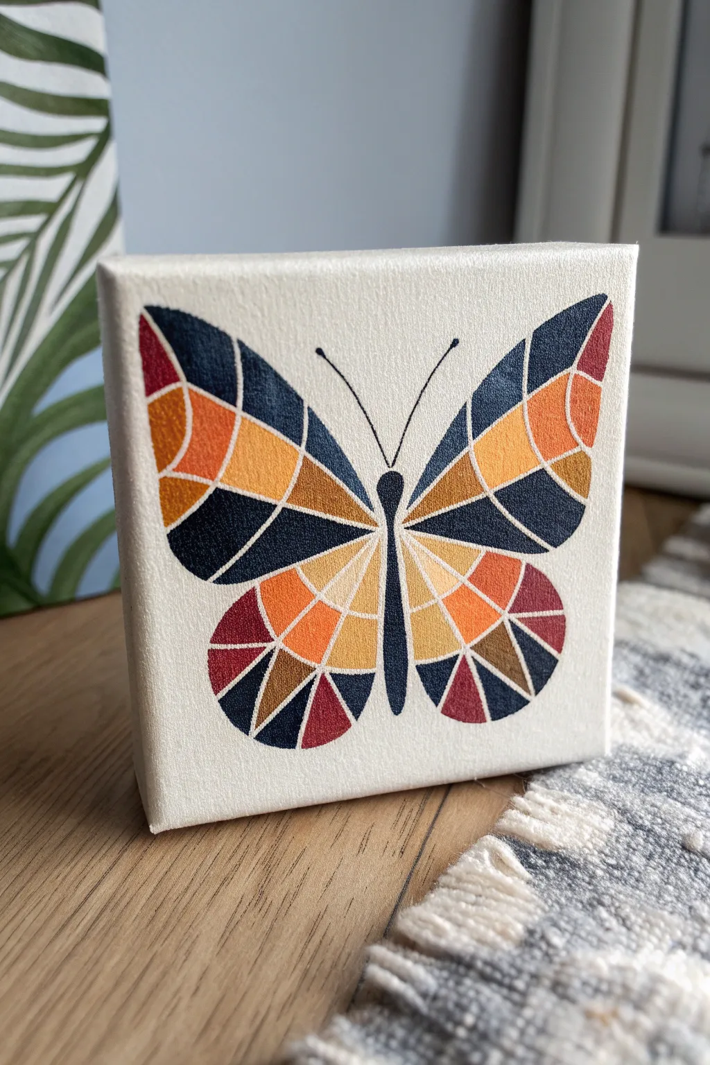 Mini canvas butterfly with bold color-block wings, simple wash background, modern boho calm.