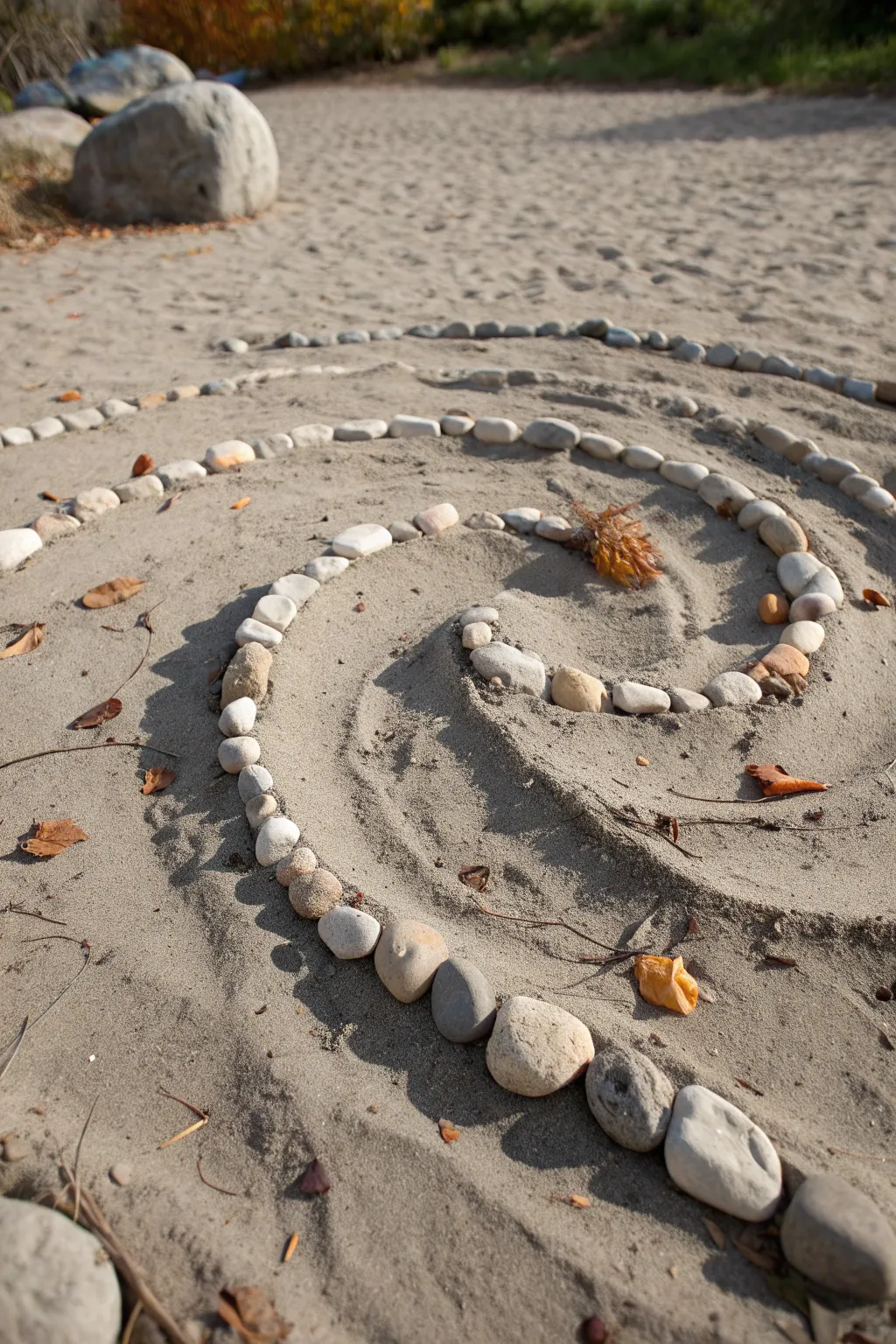 A simple spiral of stones and sticks, softly lit, earthy, and beautifully fleeting