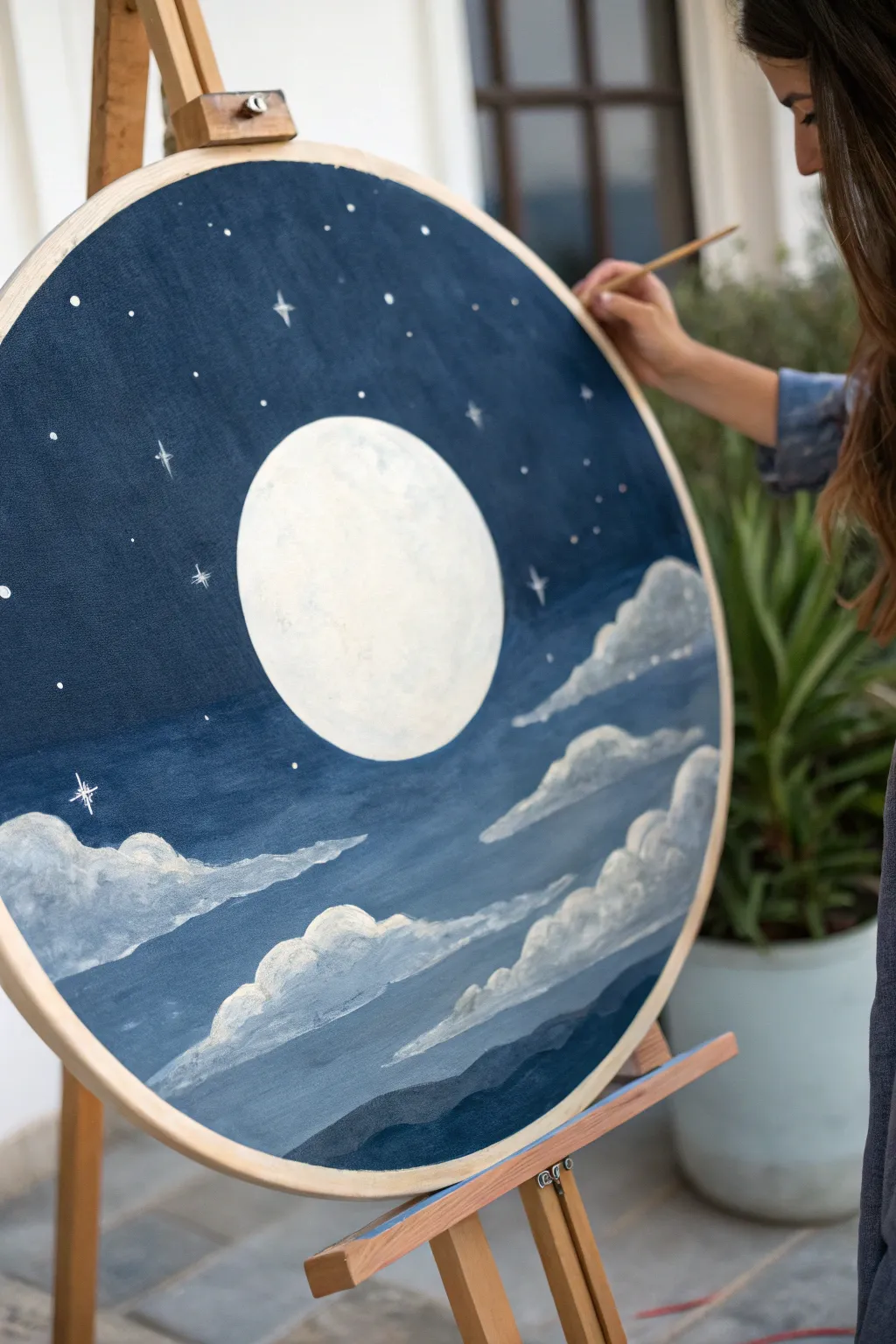 Oval moonlit night sky: a glowing off-center moon with stars curving along the top edge