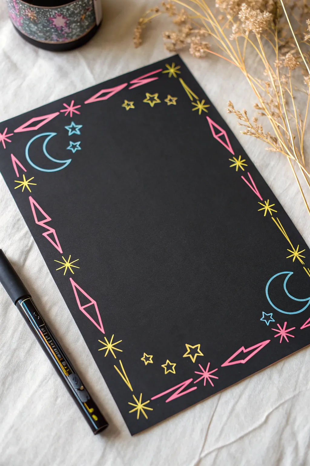 Neon paint pen doodles on black paper for bold, minimal star-and-moon drawing inspiration.