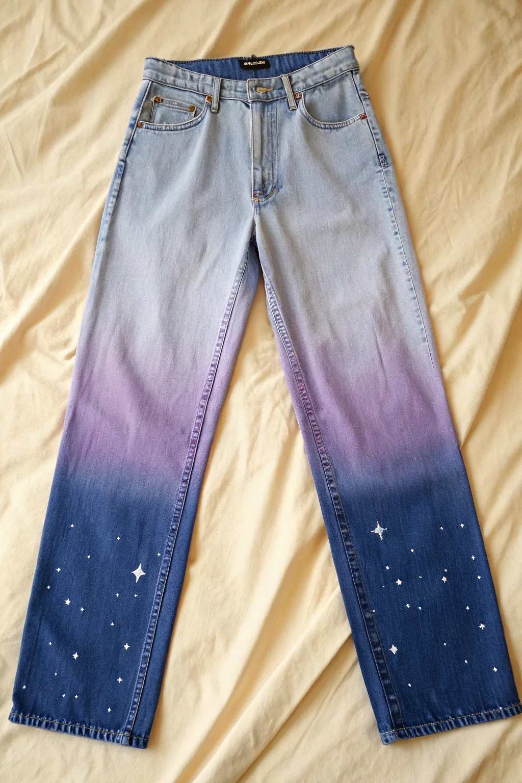 Galaxy ombre jeans with star-speckled details, minimalist styling, and a dreamy night-sky fade