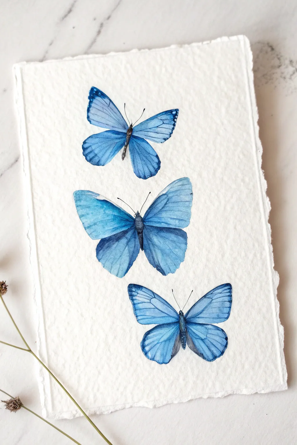 Create a stunning minimalist piece with these floating blue watercolor butterflies.