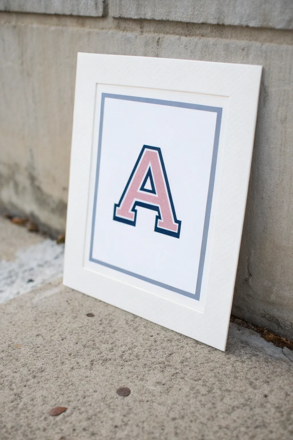 Paint a bold varsity initial in blush pink with crisp outline and shadow for instant preppy charm
