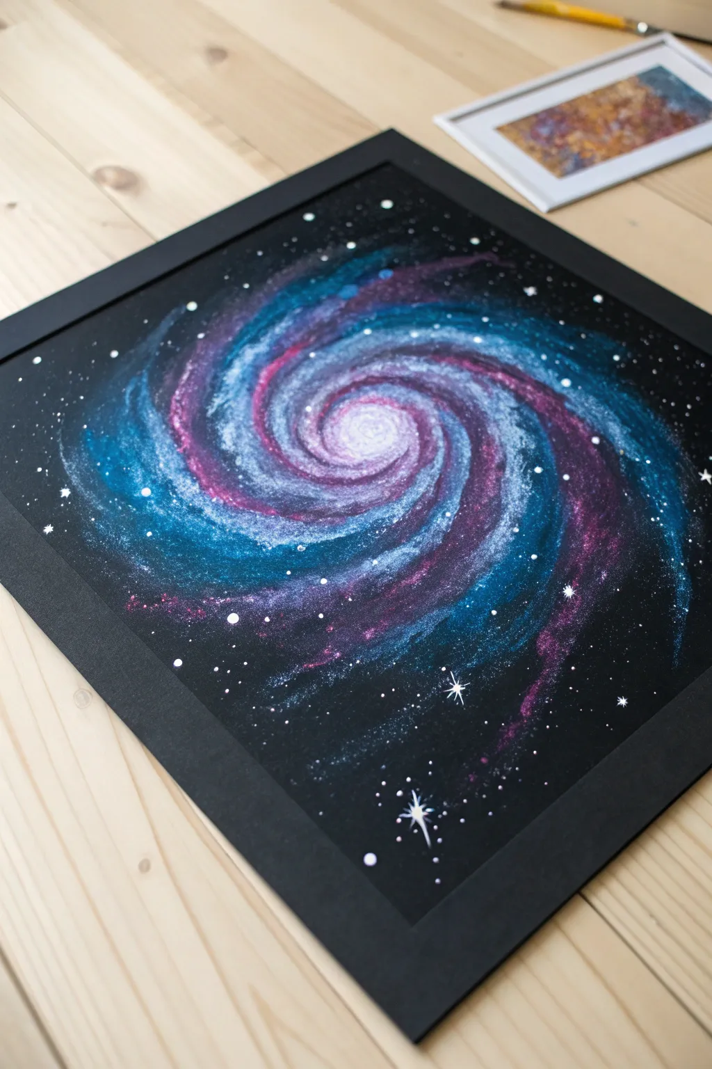 Galaxy spin art on black paper with bright planet dots and starry speckles, minimal and dreamy