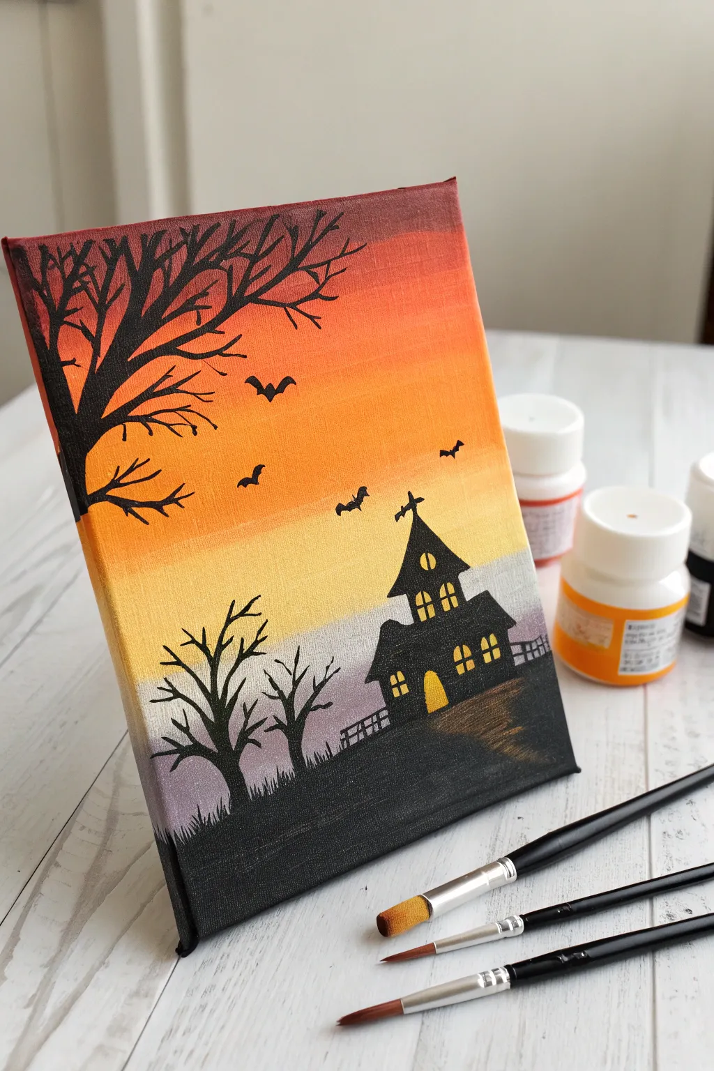 Paint a candy corn gradient sky with a bold haunted silhouette for a chic minimalist Halloween vibe