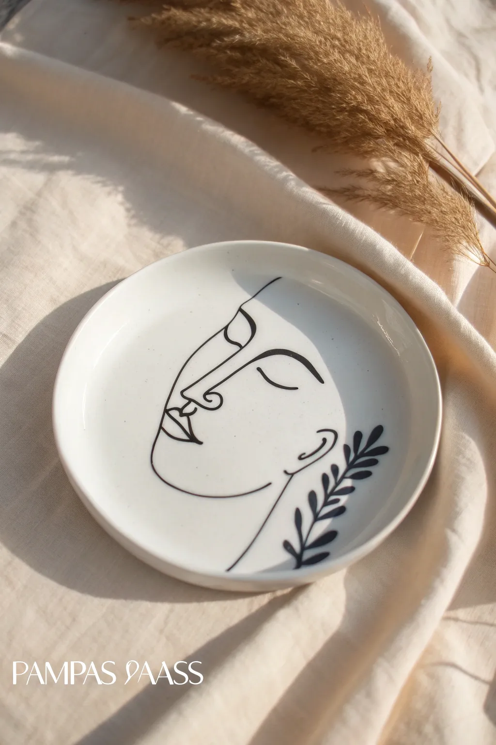 Modern one-line face on a white plate, minimalist contrast with a soft Scandinavian studio vibe