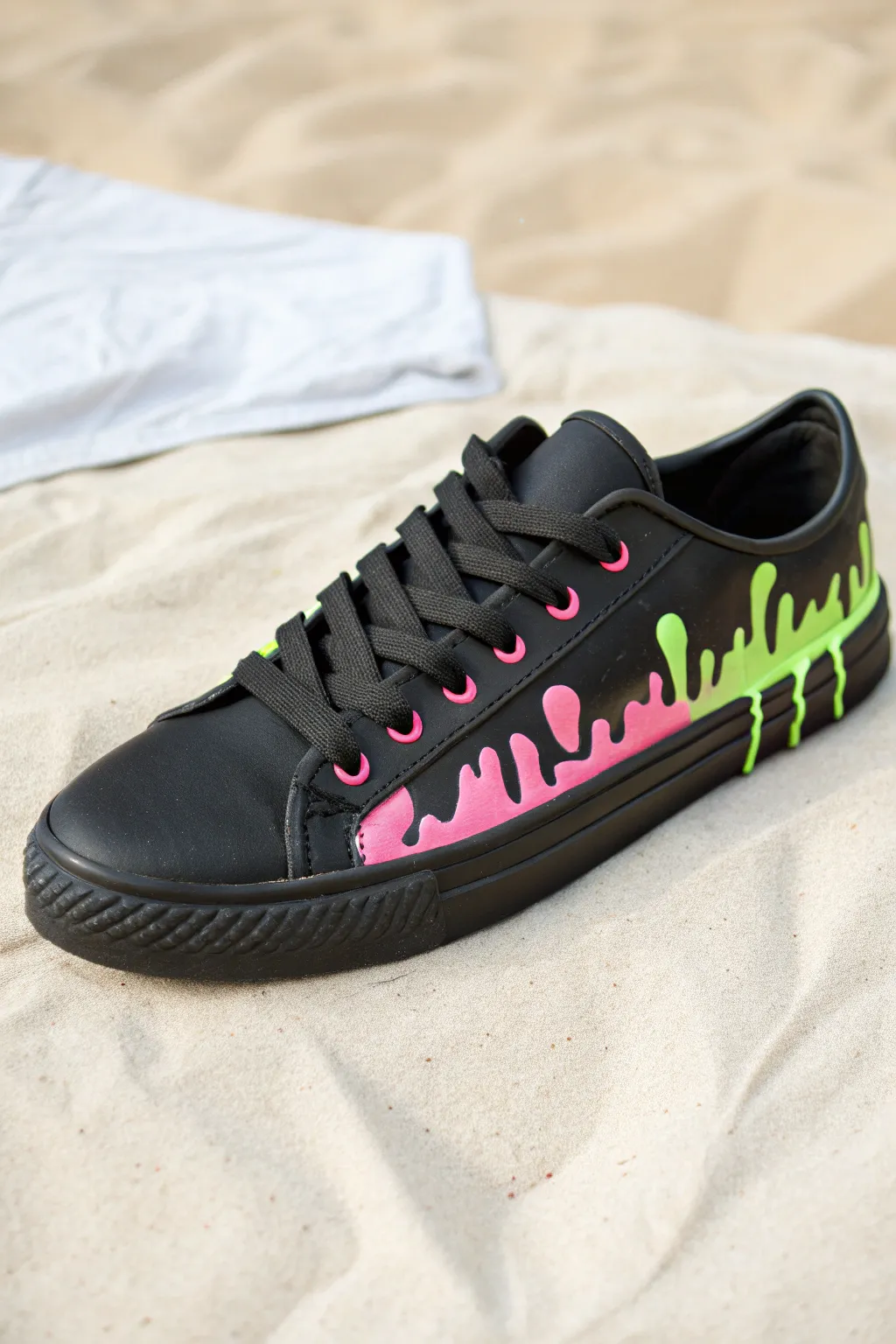 Matte black sneaker with glossy neon drips, minimalist backdrop, bold contrast for easy painting