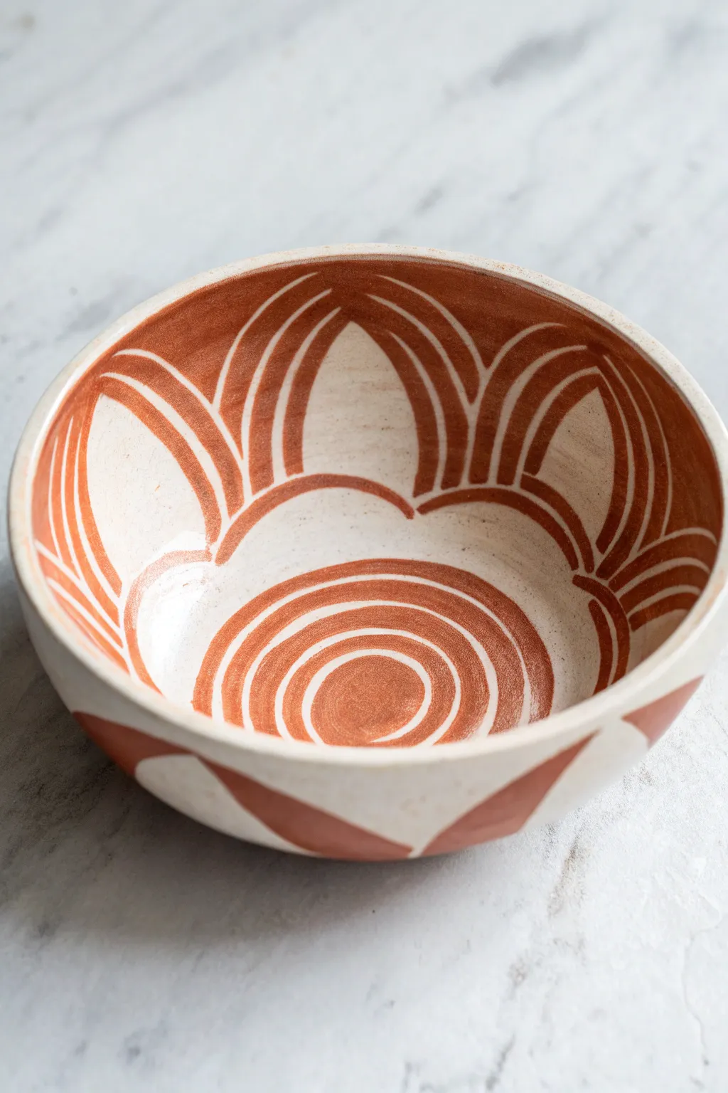 Modern abstract shapes painted inside a bowl, bold overlaps and calm negative space